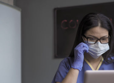 Doctor works computer in medical office.