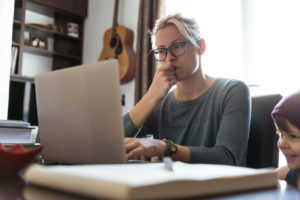A mother reviewing DIPG support resources on her computer
